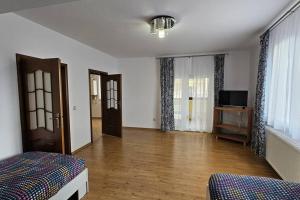 ein Wohnzimmer mit einem Bett und einem TV in der Unterkunft Radauti Residence 1P in Rădăuţi