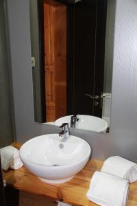 a bathroom with a white sink and a mirror at Loulé Estúdios in Porto