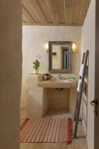 un baño con lavabo y espejo en Lethos Villa - Tinos, en Kionia