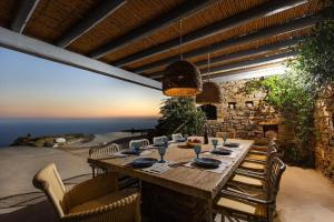 una mesa de comedor con sillas y un tableablishbestosbestosbestosbestosbesto en Lethos Villa - Tinos, en Kionia