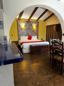 a bedroom with a bed and a table and chairs at Hotel Medrano Temáticas and Business Rooms Aguascalientes in Aguascalientes