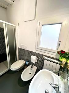 baño con lavabo y aseo y ventana en Agnolo, en Florencia