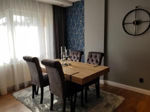 a dining room with a wooden table and chairs at Apartament LOFT-Grupa PlażoweLove in Krynica Morska