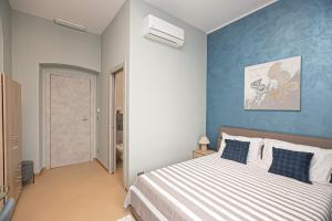 1 dormitorio con cama y pared azul en Affittacamere Gioiello, en Génova
