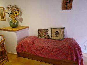 Casa Marciana 1 - Isola D'Elba في مارشيانا: غرفة نوم مع سرير مع إناء من زهور الشمس