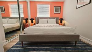 um quarto com uma cama grande e paredes cor-de-laranja em The Lofts on Clematis 601 Downtown West Palm Beach em West Palm Beach