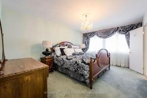 a bedroom with a bed and a chandelier at The Bruce Trail Retreat in St. Catharines