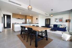 a kitchen and living room with a wooden table and chairs at Lumina at Flats Punta Cana Village in Punta Cana
