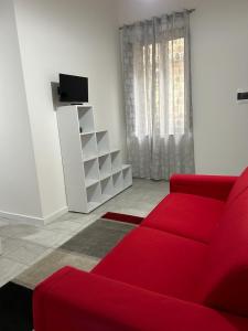 a living room with a red couch and a tv at B&B Il Sogno in Lamezia Terme
