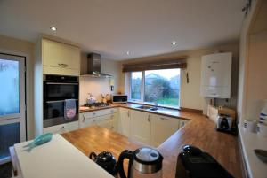 a kitchen with white cabinets and a large window at Stronvar- coastal home with sea views in Pittenweem