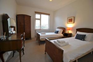 1 dormitorio con 2 camas, escritorio y TV en Stronvar- coastal home with sea views, en Pittenweem