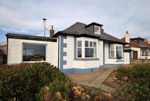 a white house with a black roof at Stronvar- coastal home with sea views in Pittenweem