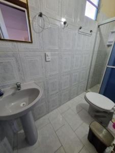 a white bathroom with a sink and a toilet at Pousada Iakã Boipeba in Cayru