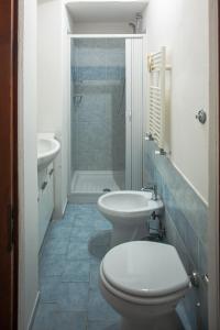 La salle de bains est pourvue de toilettes, d'un lavabo et d'une douche. dans l'établissement All'ombra del Campanile, à Volterra