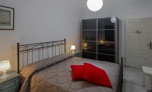 - une chambre avec un lit doté d'un oreiller rouge dans l'établissement All'ombra del Campanile, à Volterra