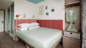 1 dormitorio con 1 cama con cabecero rojo y almohadas blancas en The Goodtime Hotel, Miami Beach a Tribute Portfolio Hotel en Miami Beach