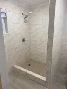 a shower with a glass door in a bathroom at Chez Rose Bungalow in Nassau