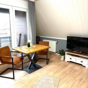 ノルトダイヒにあるAuszeit Norddeich Hannes I 5 Minuten zu Fuß zum Meerの木製のテーブルとテレビのあるリビングルーム