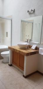 a bathroom with a sink and a toilet and a mirror at La Casa del Lago in Valle de Bravo