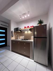eine Küche mit einem Kühlschrank aus Edelstahl in einem Zimmer in der Unterkunft Casa Venado in Puerto Morelos