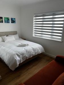 a white bed in a bedroom with a window at The Barrington Hotel in New Barnet