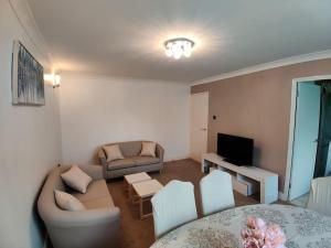 a living room with a couch and a table at Cosy and modern two bedroom flat near Heathrow in Hayes