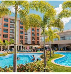 una piscina resort con palmeras y gente en ella en Thermas Alta Vista, en Caldas Novas