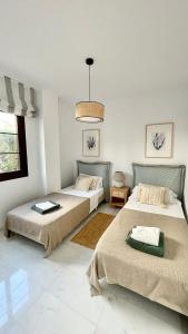 um quarto com 2 camas e um lustre em HOUSE WITH PRIVATE GARDEN em Finestrat