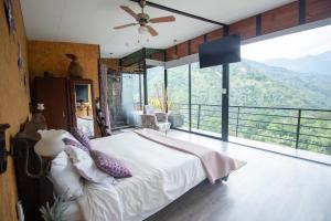sypialnia z łóżkiem i dużym oknem w obiekcie Magma "Eco Hotel Cabañas" w mieście La Vega