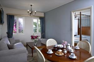 a living room with a table and chairs and a couch at Dafnoudi Hotel Apartments in Fiskardo