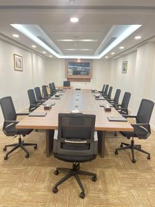 une grande salle de conférence avec une grande table et des chaises dans l'établissement Mena East Suites Dammam, à Dammam