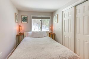 a bedroom with a large bed with a window at Quiet Mountain-View Home Near Conway and Hiking in Fryeburg