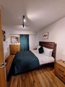 a bedroom with a large bed and a bathroom at Five Lamps Suites in Dublin