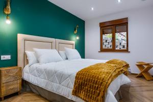 um quarto com uma cama grande e uma parede verde em Apartamentos Montes Vindios em Cangas de Onís