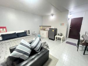 暖武里的住宿－Impact Arena C3 Milo，一间带黑色沙发的客厅和一间厨房