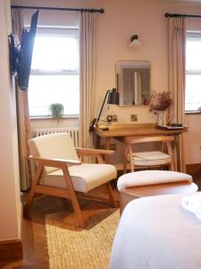 a bedroom with a desk and chairs and a mirror at The Tempest Arms in Skipton