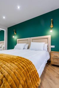a bedroom with two beds and a green wall at Apartamentos Montes Vindios in Cangas de Onís