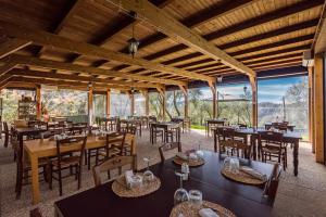 - un restaurant avec des tables, des chaises et de grandes fenêtres dans l'établissement Un'Ottima Annata B&B, à Montedivalli Chiesa