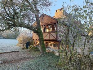 una casa con un albero di fronte di Chambres d'hôte Mas de Bouzou a Grèzes