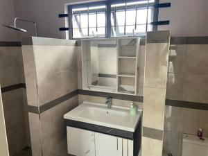 un bagno con un lavandino, uno specchio e una finestra di Residence 1129 - Block 1 a Flic-en-Flac