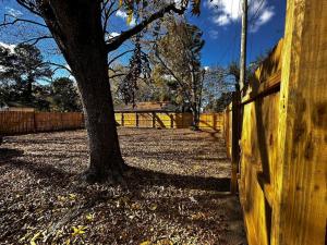 a wooden fence with a tree next to a wooden fence at Renovated,Comfortable and Convenient Experience in Rocky Mount