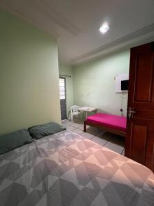 1 dormitorio con 1 cama grande y un banco rosa en Hotel Shalon en Rio Branco