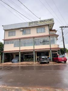 a hotel station with cars parked in front of it at Hotel Shalon in Rio Branco