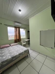 a bedroom with a bed and a flat screen tv at Hotel Shalon in Rio Branco