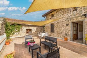 eine Terrasse mit Stühlen, einem Tisch und einem Gebäude in der Unterkunft Un'Ottima Annata B&B in Montedivalli Chiesa