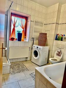 a bathroom with a washing machine and a tub at Ferienzimmer Healing und Montuerwohnung in Weißenfels