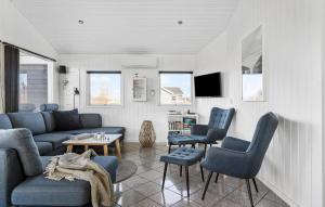 オテルプにあるAmazing Home In Otterup With 3 Bedrooms, Sauna And Wifiのリビングルーム(青い椅子、ソファ付)