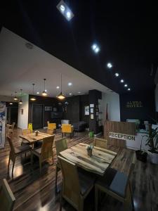 un restaurante con mesas de madera, sillas y luces en Hotel Alysa Korce, en Korçë