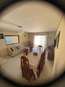 ein Esszimmer und ein Wohnzimmer mit Tisch und Stühlen in der Unterkunft Casa de praia em Tamandaré - Carneiros in Tamandaré