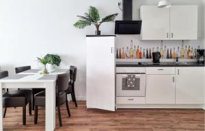 a kitchen with white cabinets and a table with chairs at Pet Friendly Apartment in Zahren